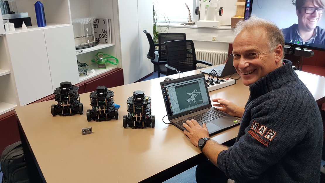 Prof. Olaf Just mit drei Turtle Bots im Labor