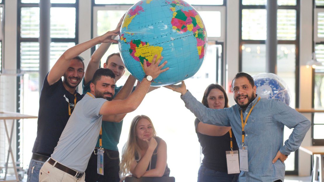 internationale Studierende mit einem Globus