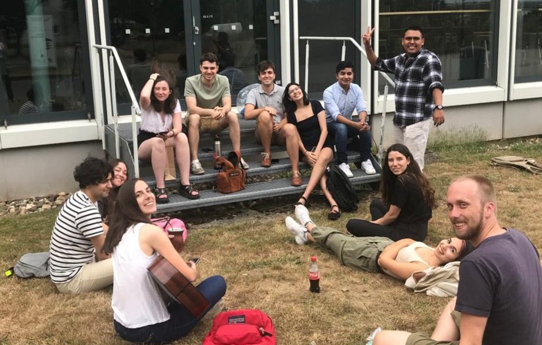 Gruppe von Studierenden sitzt im Gras und macht Pause 