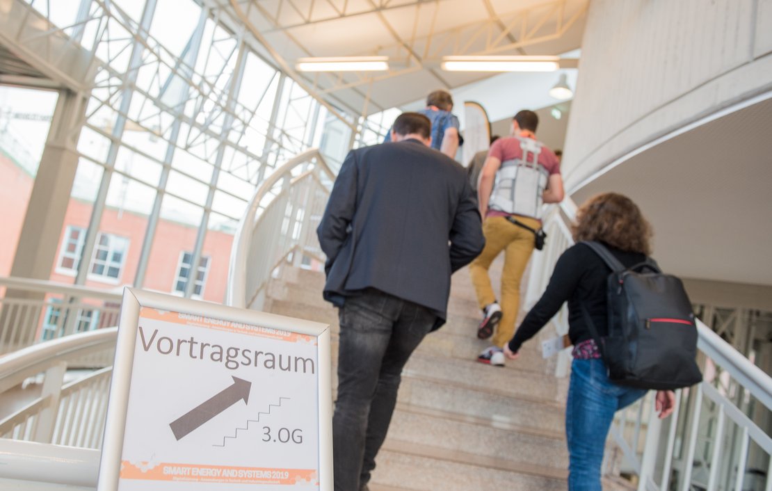 Teilnehmer der Smart Energy 2019 gehen eine Treppe hinauf