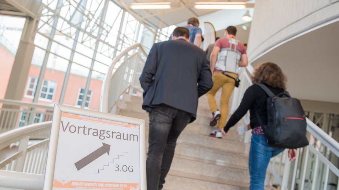 Teilnehmer der Smart Energy 2019 gehen eine Treppe hinauf